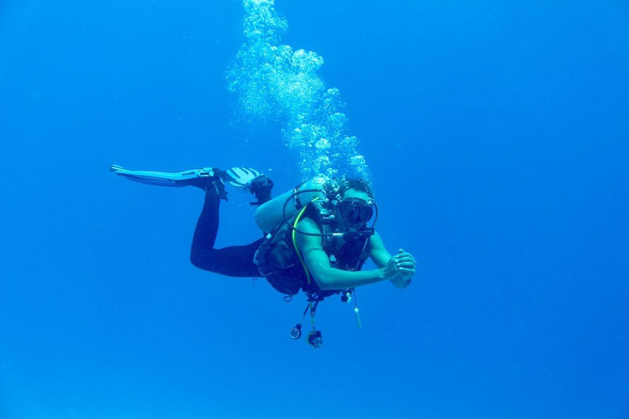 Diver swimming in open blue water