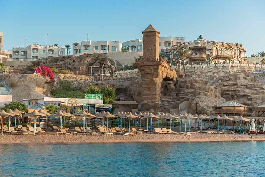 The bay’s shoreline with beach umbrellas and flowering gardens