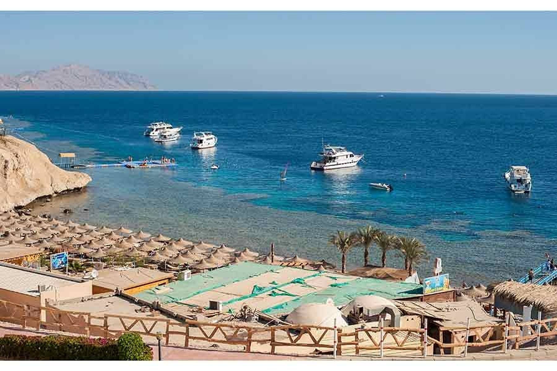 Boats moored in turquoise water off the beach