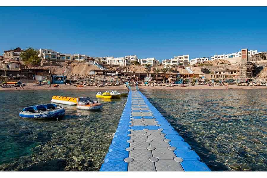 Blue jetty with boats in the bay