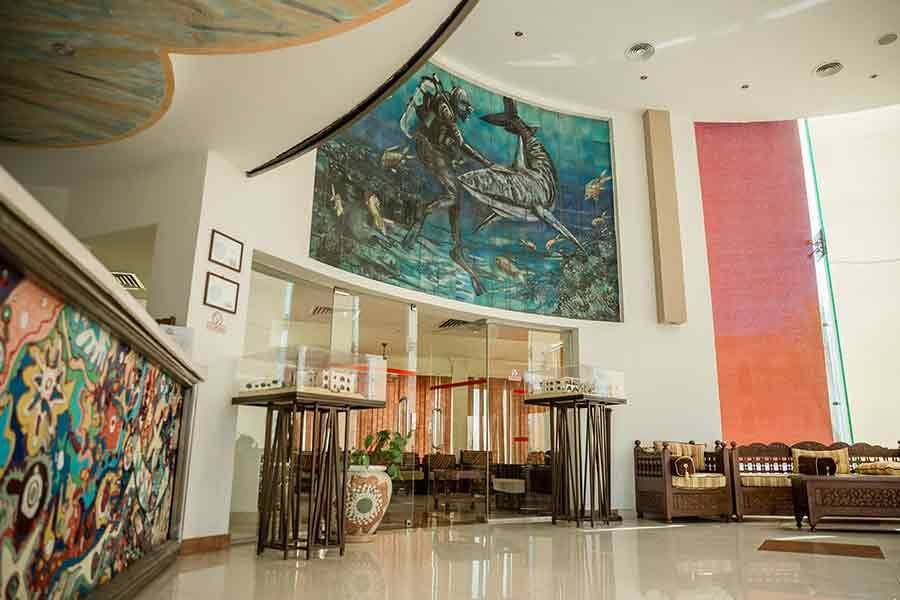 Reception lounge with a large marine mural and wooden seating
