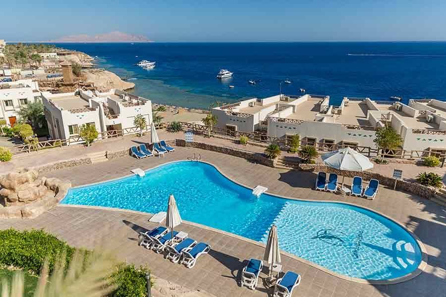 Pool with loungers set into the hillside above the bay