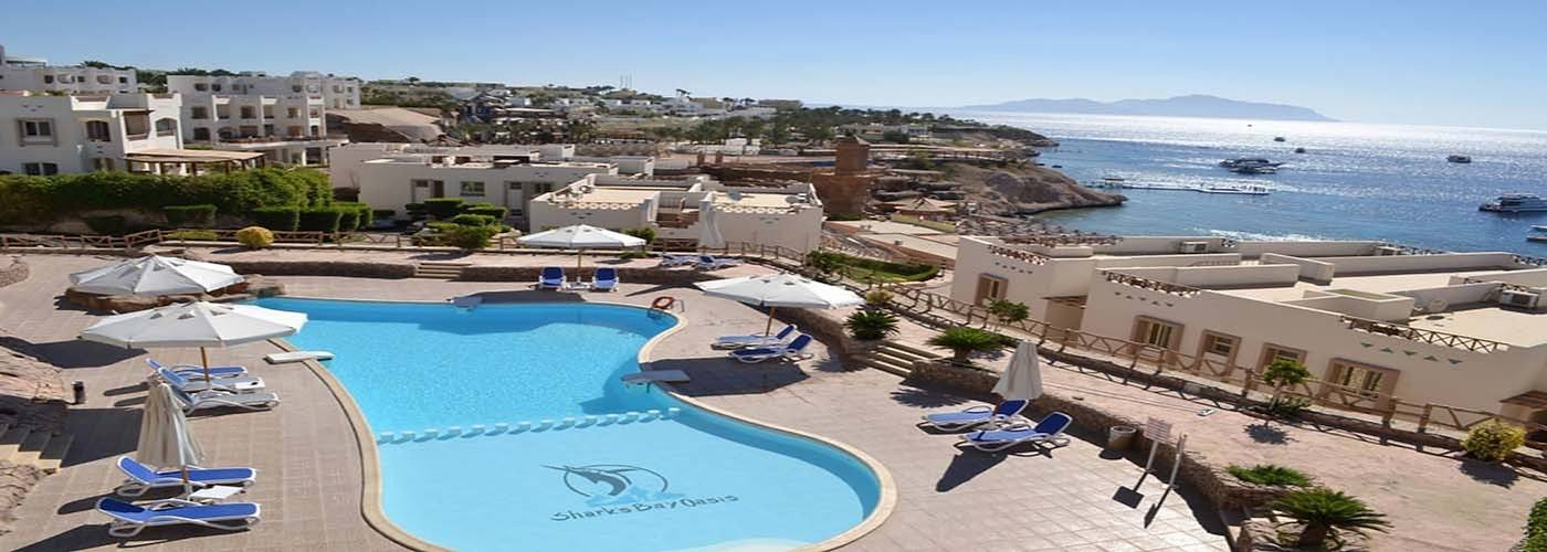 Wide view of a curved pool and sun loungers on the resort terraces