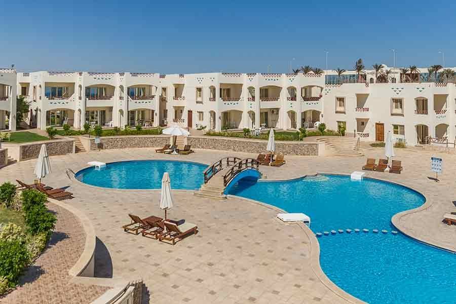 Two connected pools on a stone terrace overlooking the bay