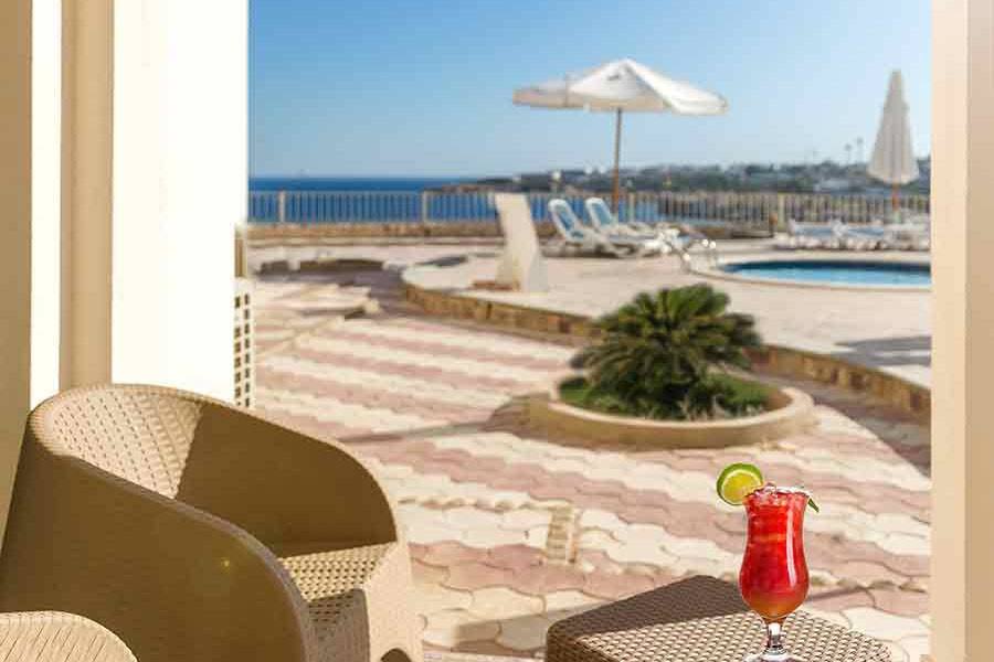 A chilled drink on a poolside table in the sun